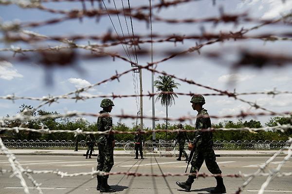 Thai soldiers man a checkpoint near pro-government "red shirt" supporters encampment in suburbs of Bangkok